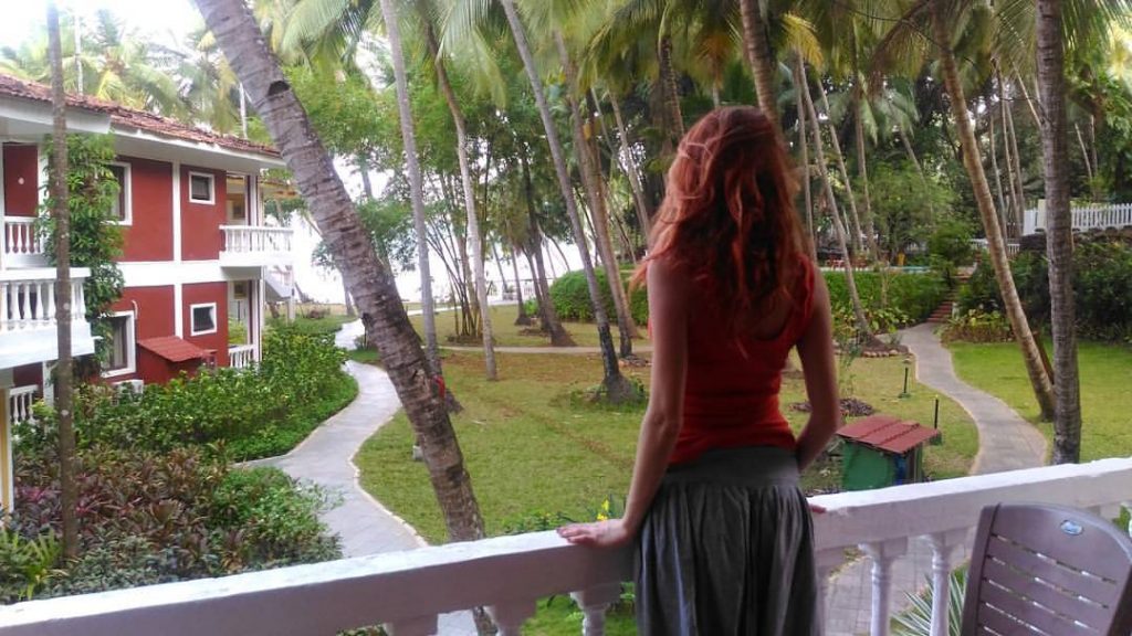 Девушка на балконе виллы в Гоа.