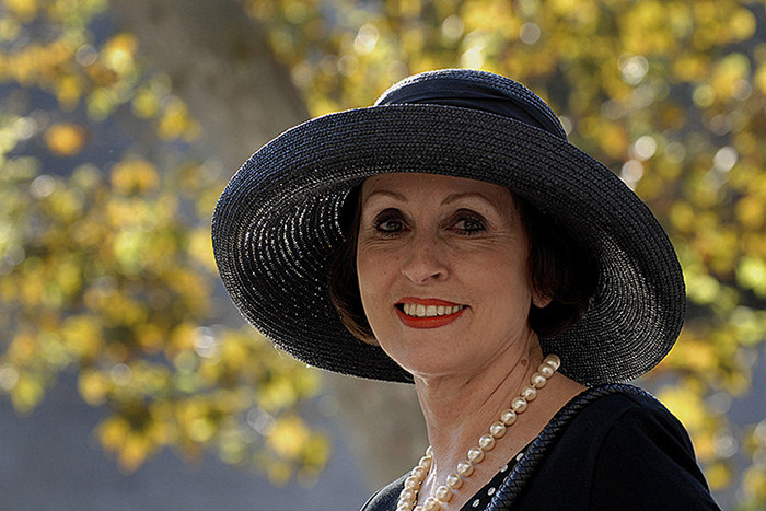 Дама в шляпе собирается отмечать день учителя.