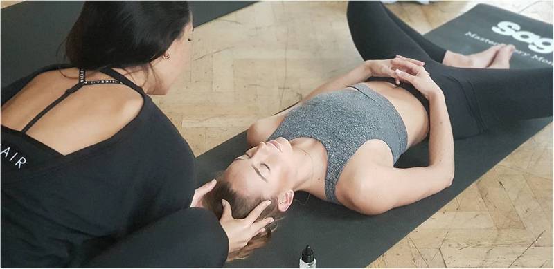 Инструктор по йоге делает точечный массаж.