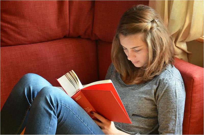 Девушка читает книгу, работа и личная жизнь одновременно.