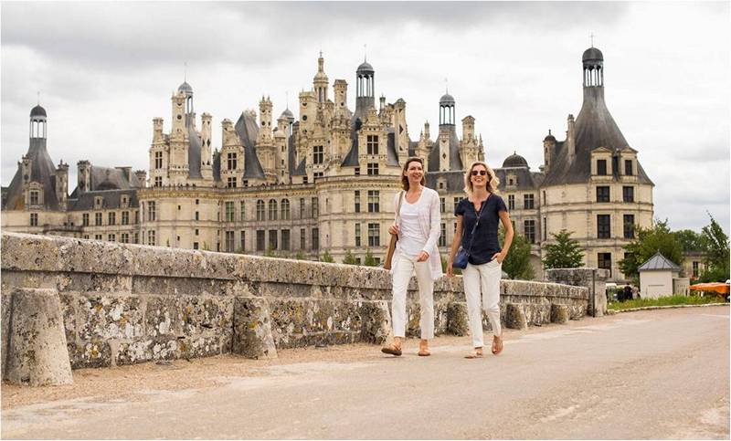 Две девушки гуляют рядом со старинным замком.