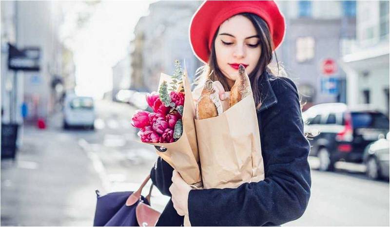 Француженка в красной беретке с цветами и круассанами думает про секреты идеальной фигуры.