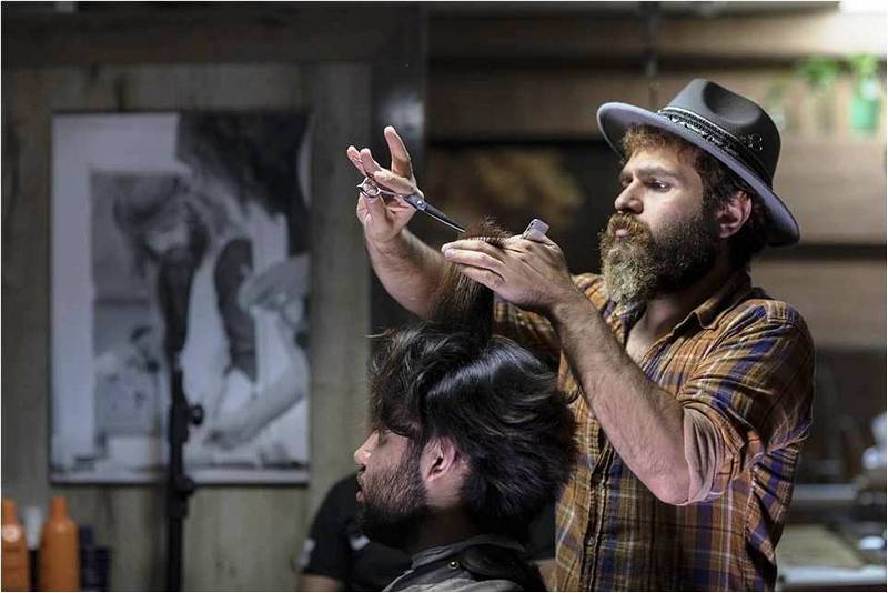 Мужчина-парикмахер работает в удовольствие.