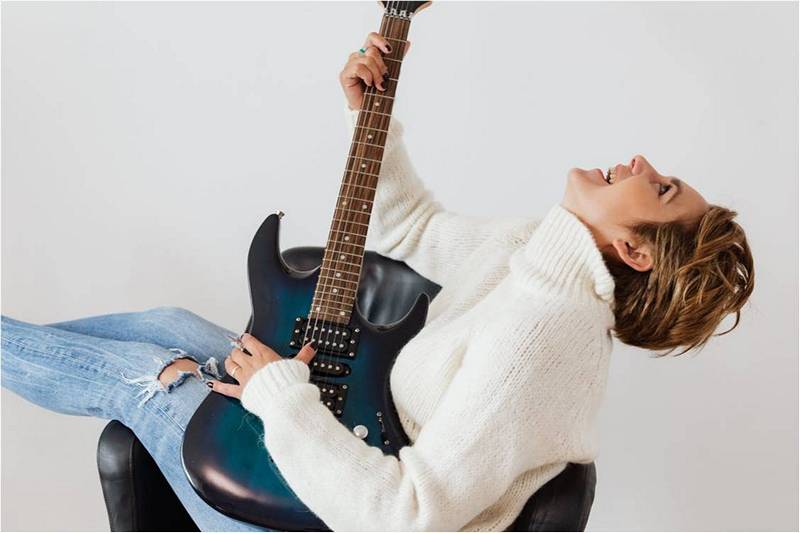 Девушка с гитарой на стуле.