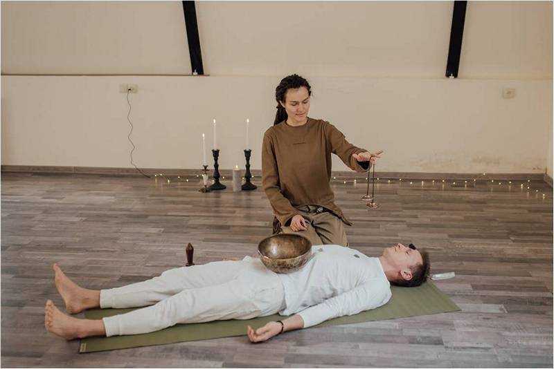 Мужчина лежит на полу, лечение звуками.